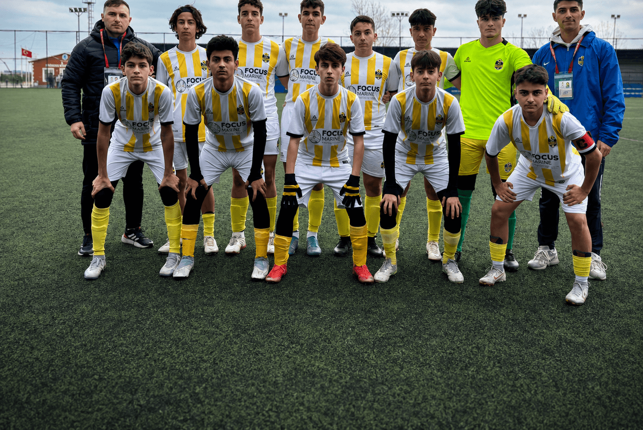 Bulutlu havada sahada dizilmiş beyaz-sarı deplasman formalı Tuzla Siyah Çoraplılar kadrosu